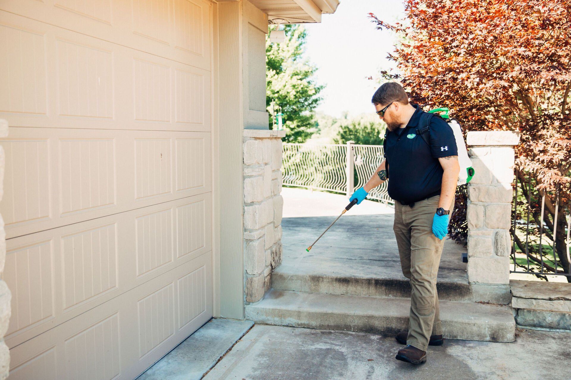 An Atkins Inc. exterminator sprays the exterior of a mid-Missouri home to prevent pests from entering the home.