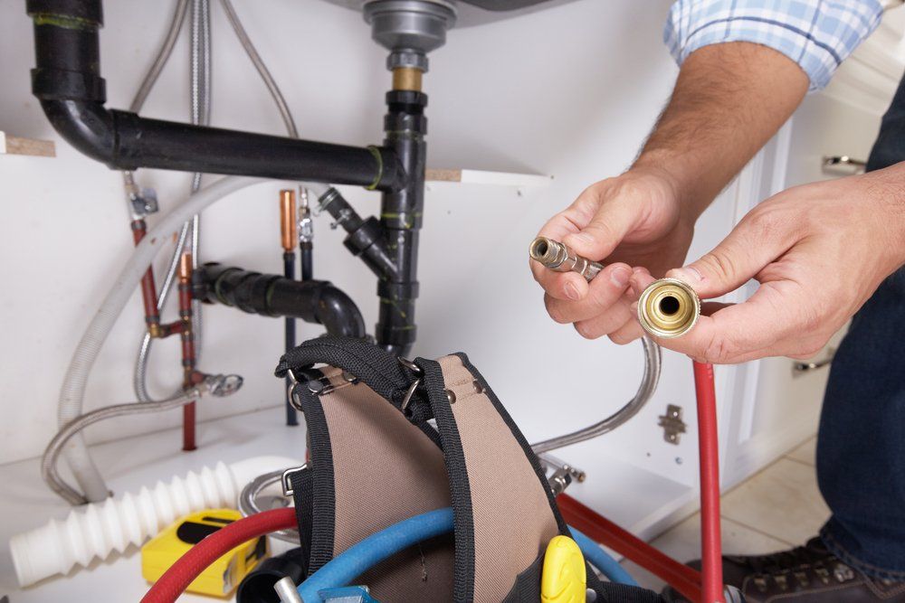 Plumber with Plumbing Tools on the Kitchen — Fletcher's Plumbing & Gas Fitting Pty Ltd in Katherine, NT
