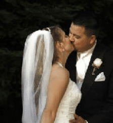 A bride and groom are kissing on their wedding day.