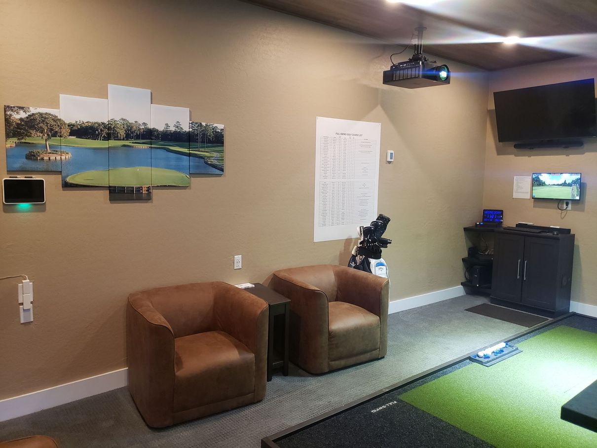 A living room with a couch , chairs and a projector.