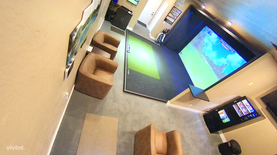 There is a golf simulator in the middle of the room.