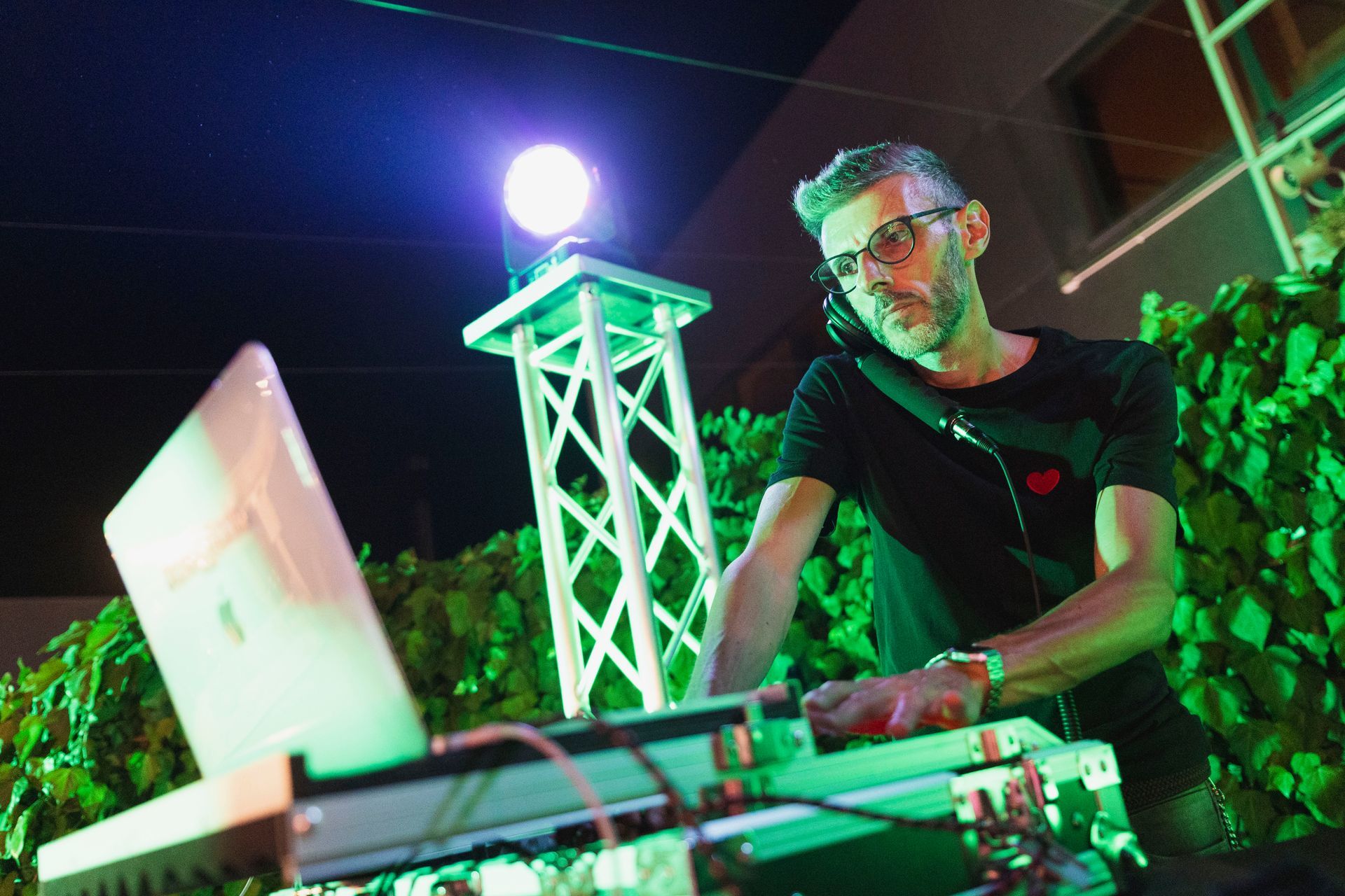 Un uomo sta ascoltando musica su un computer portatile durante una festa.