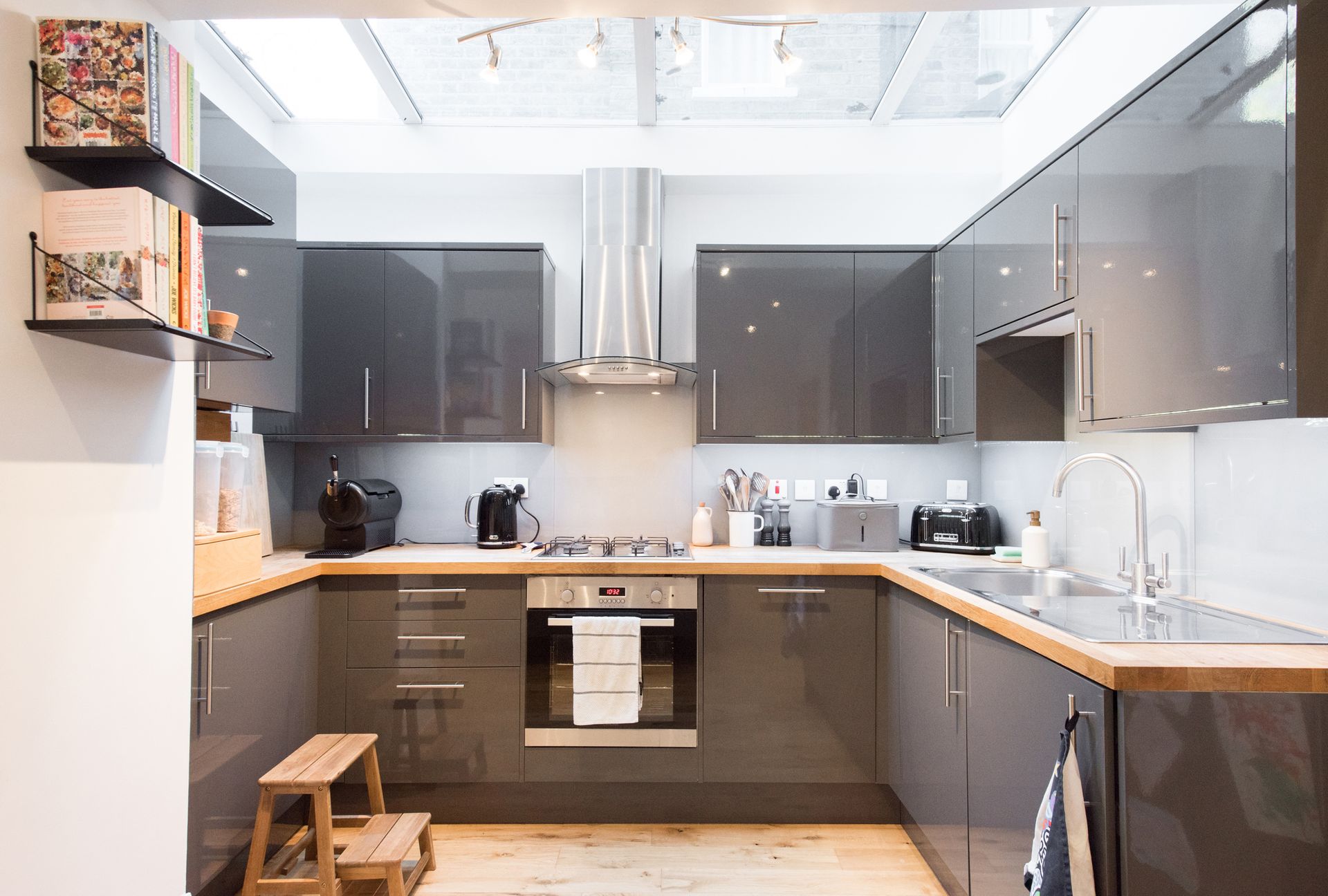 A kitchen with gray cabinets and wooden counter tops