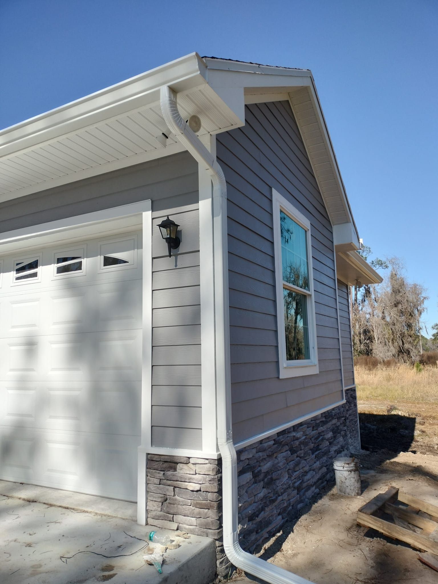 The side of a house with a garage and a window.