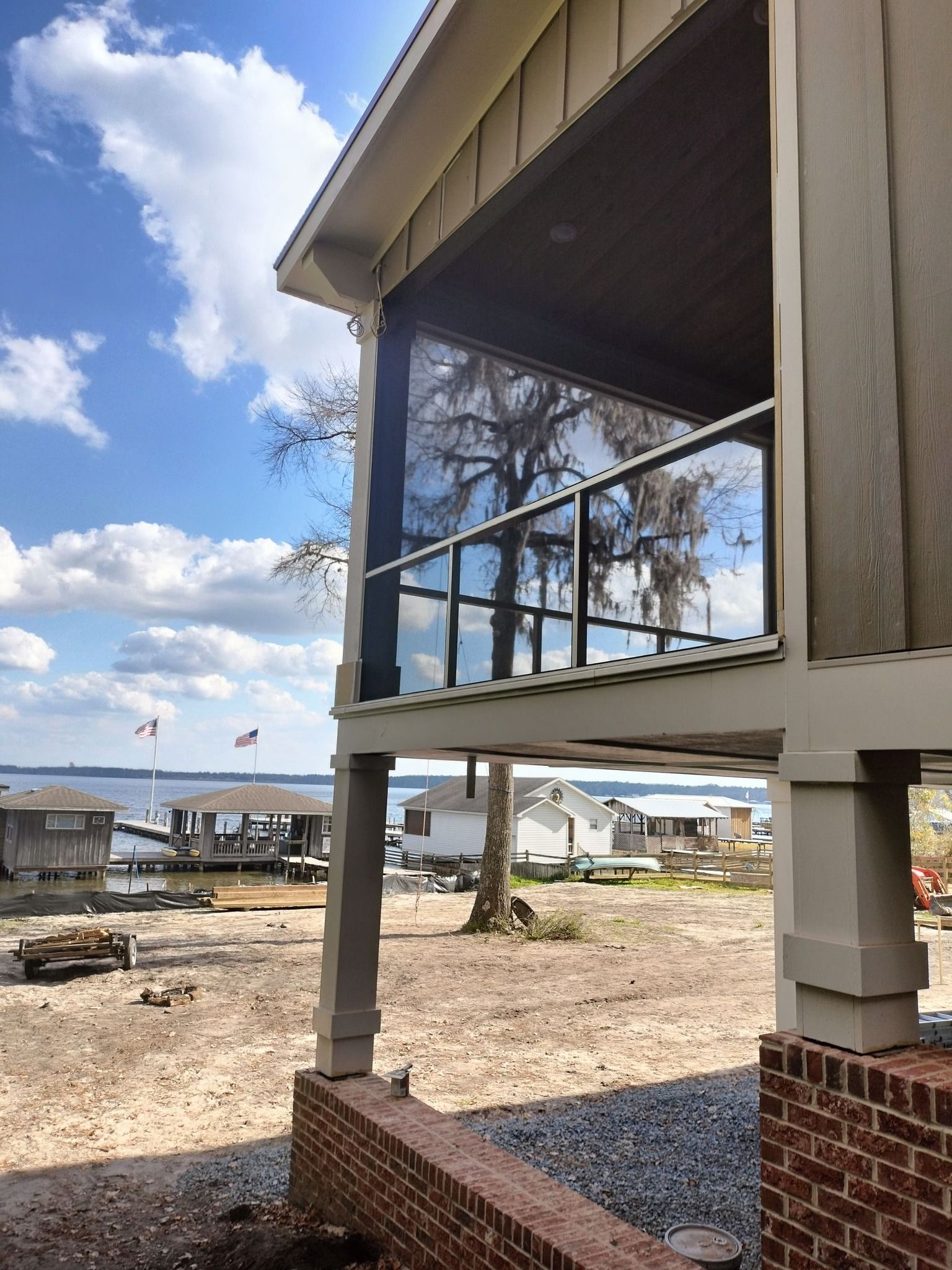 A house with a screened in porch overlooking a body of water