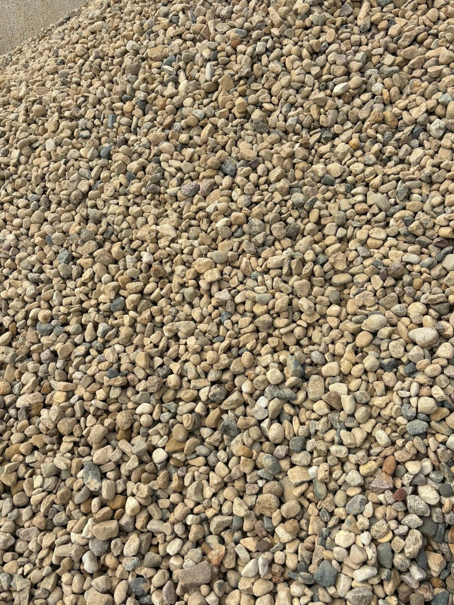 Pile of small tan and gray pebbles covering the ground