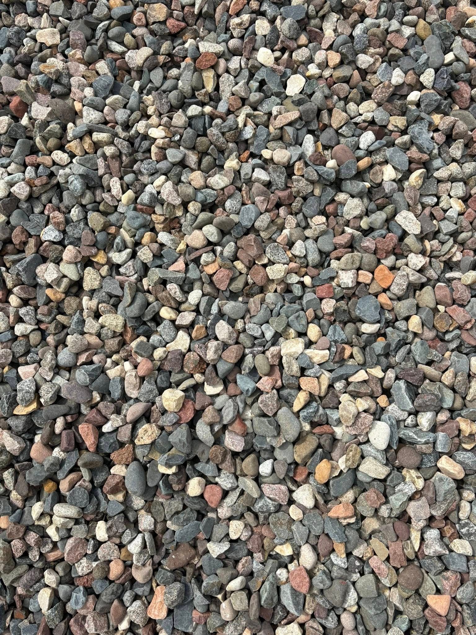 Close-up of mixed gray, brown, and white gravel stones covering the ground