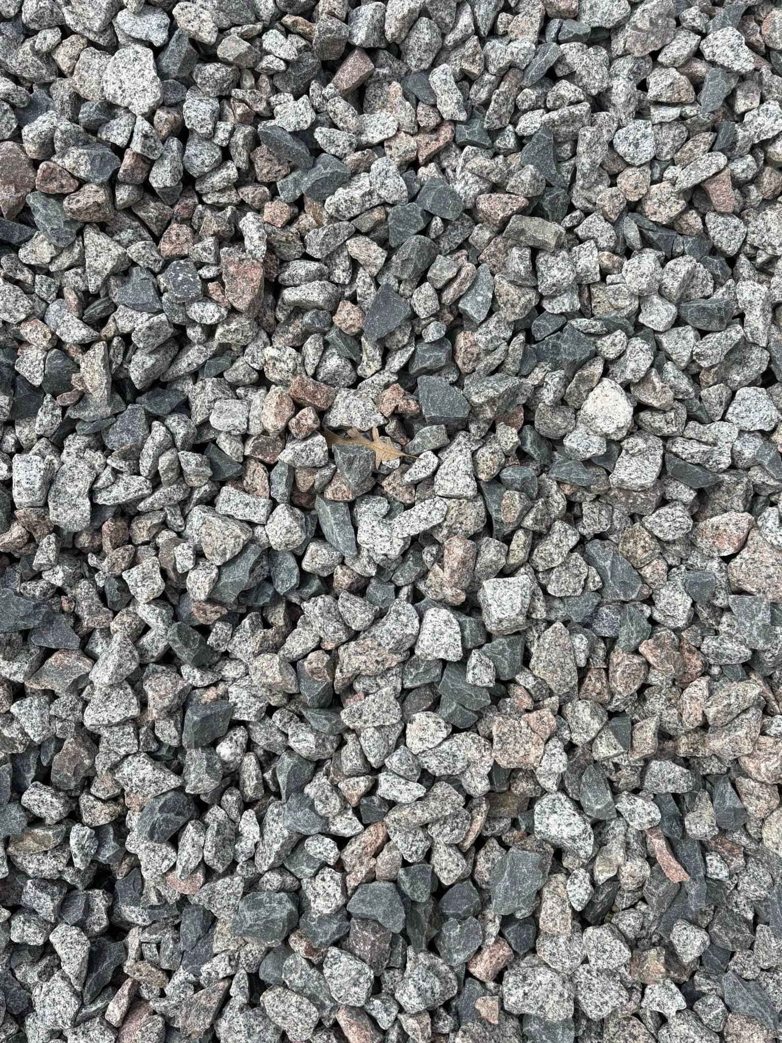 Close-up of gray gravel stones with a few brown and white pebbles scattered throughout
