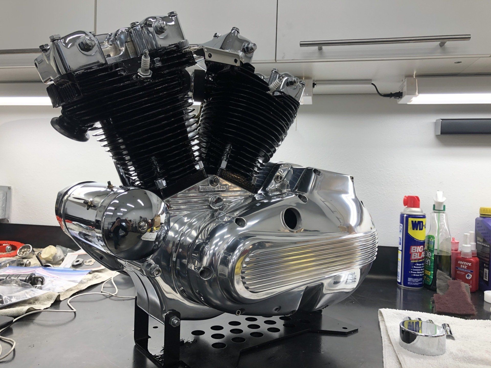 Chrome V-twin motorcycle engine on a workbench in a garage or workshop