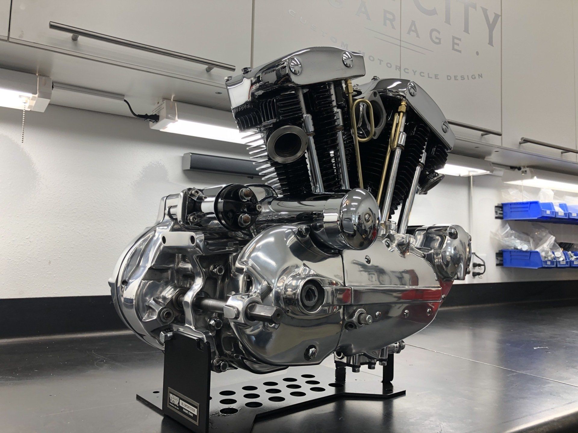 Chrome engine on a display stand in a clean showroom or museum.