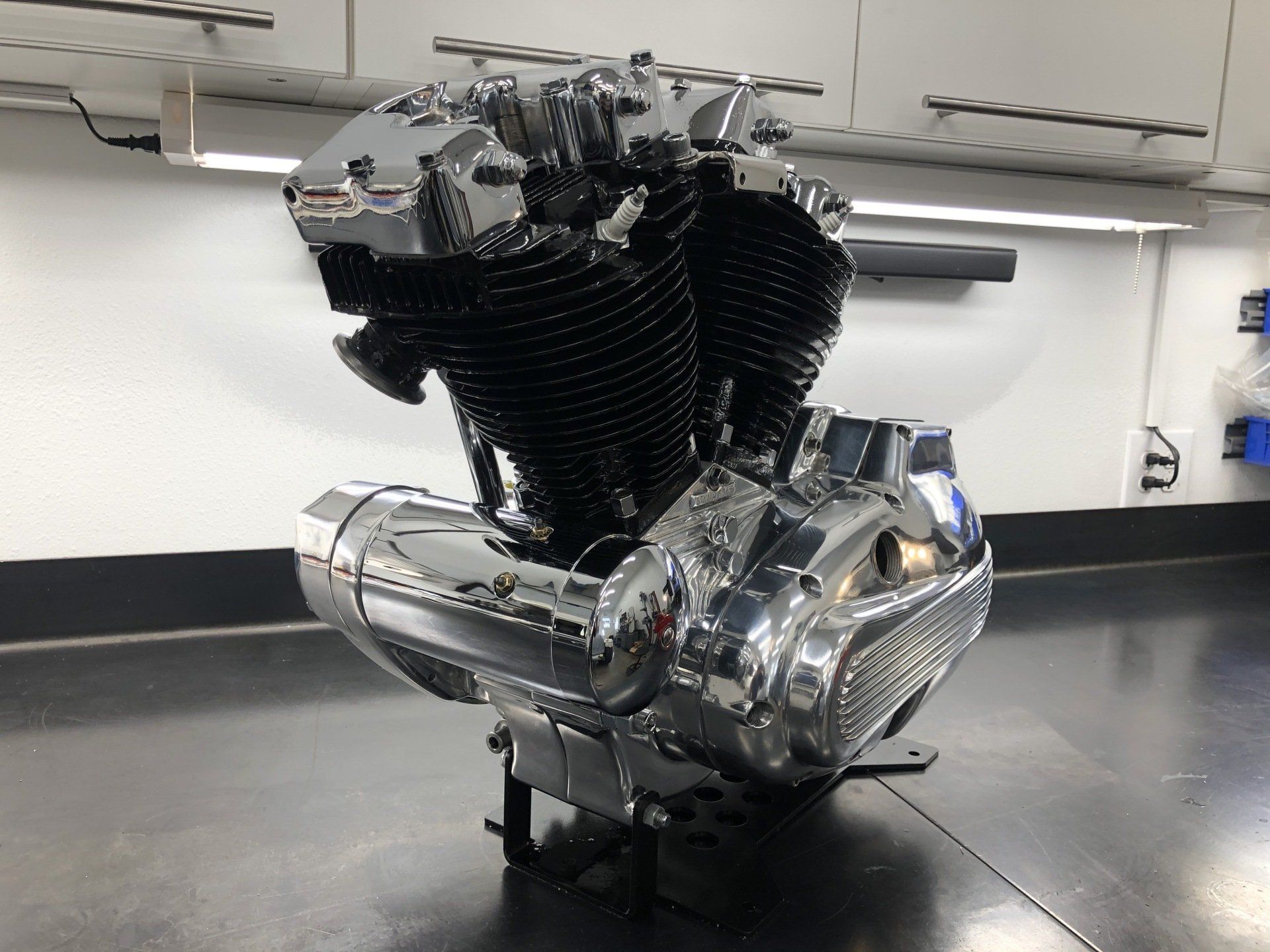 Chrome motorcycle engine on a stand in a workshop garage