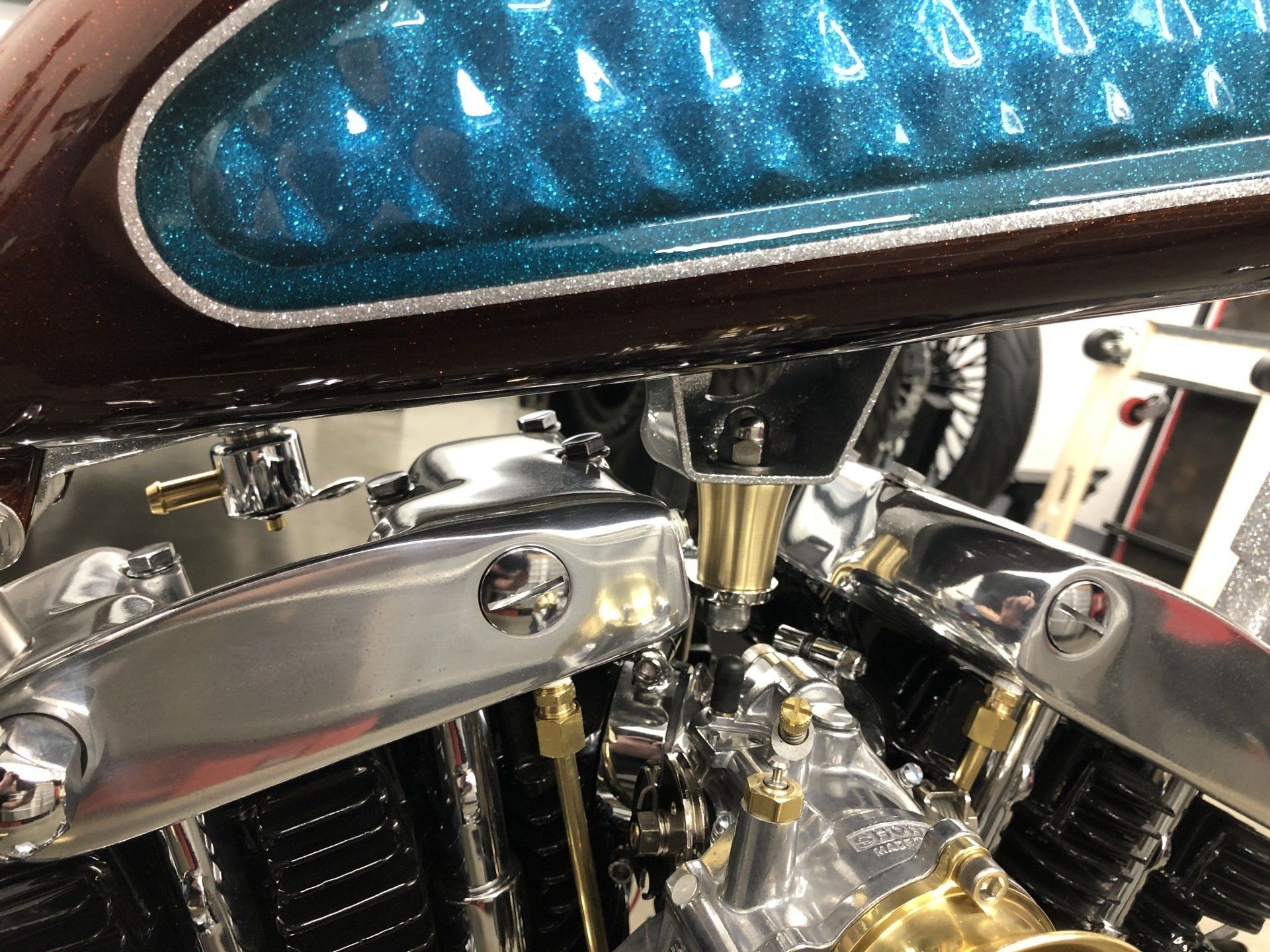 Close-up of a chrome motorcycle engine with a blue tank and polished metal details