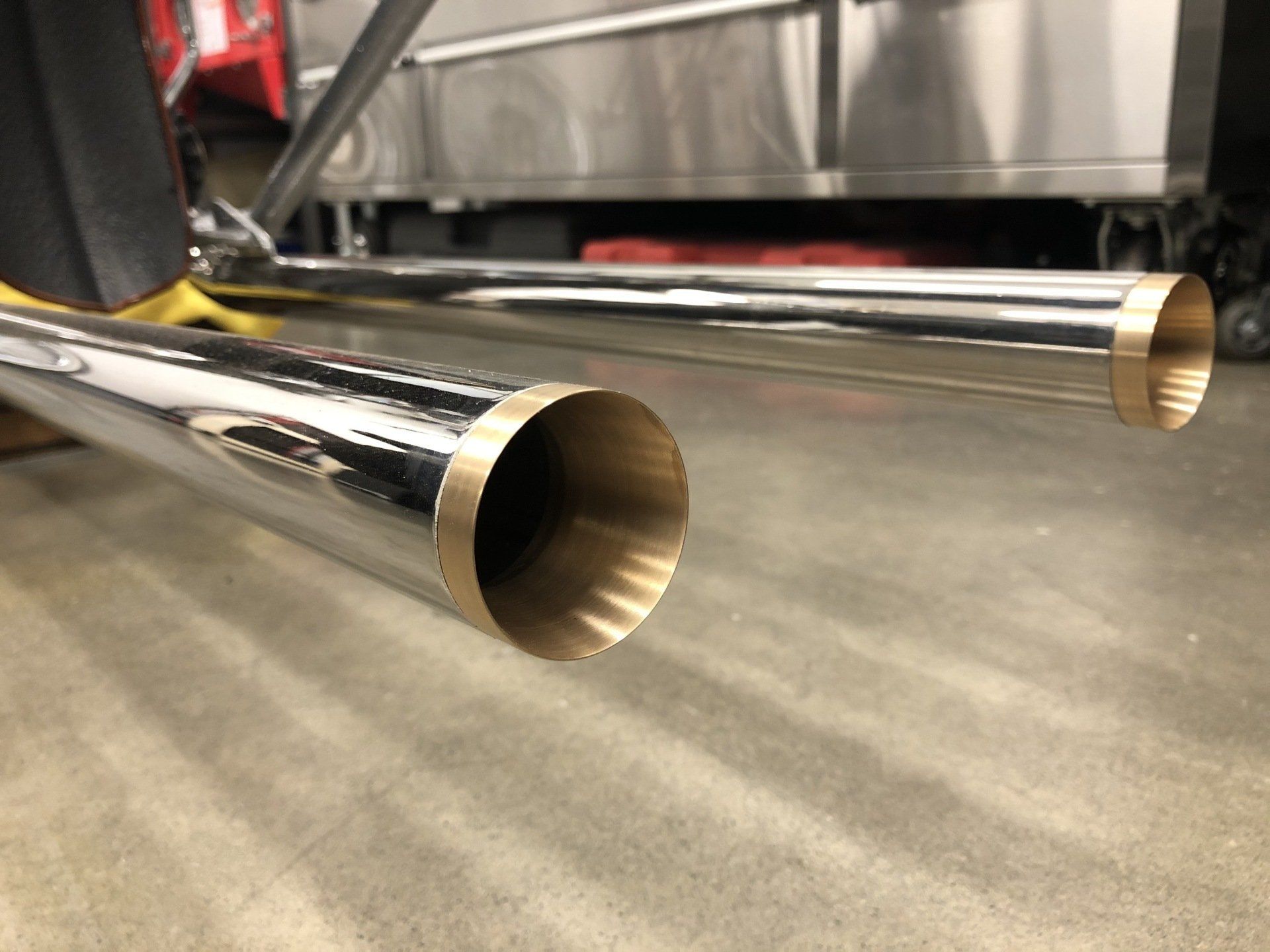 Two chrome exhaust pipes extending from the rear of a vehicle