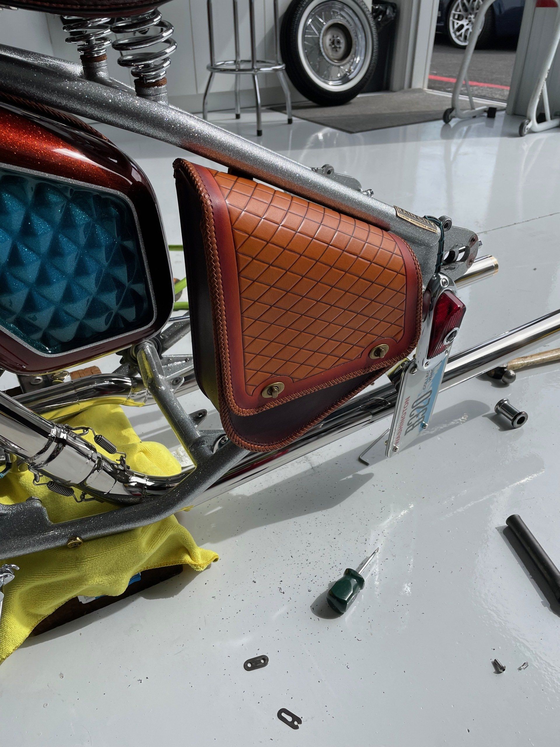 Close-up of a custom car interior with blue and orange quilted panels and exposed metal frame.