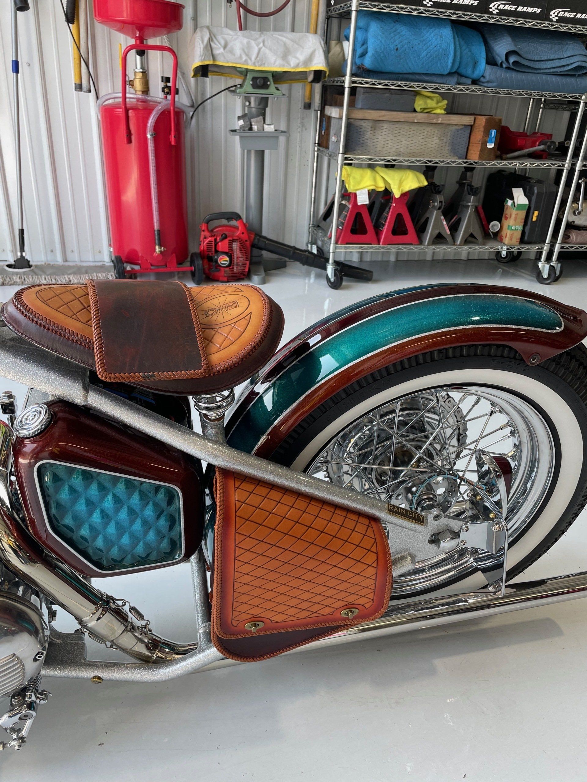 Custom trike with teal and brown accents in a garage, shown in side view