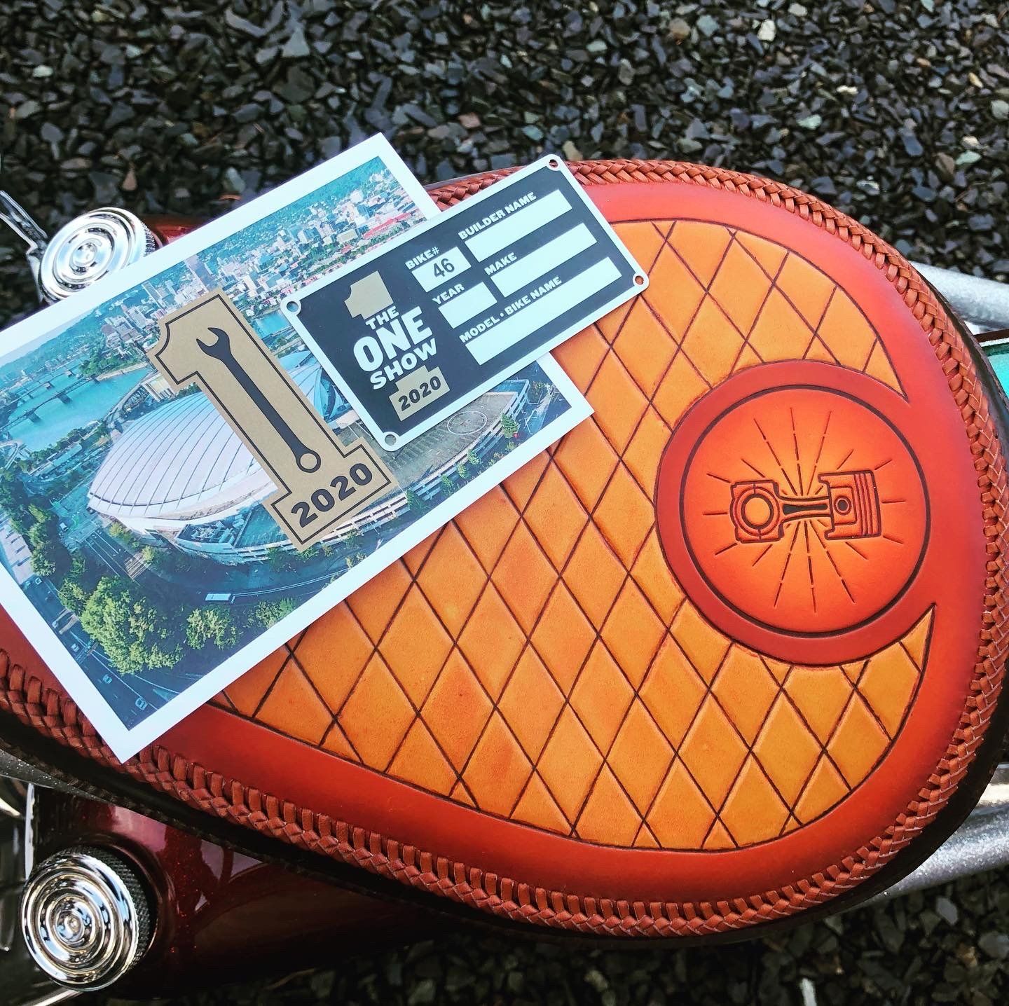 Orange quilted leather pouch with travel stickers and a blue postcard on top