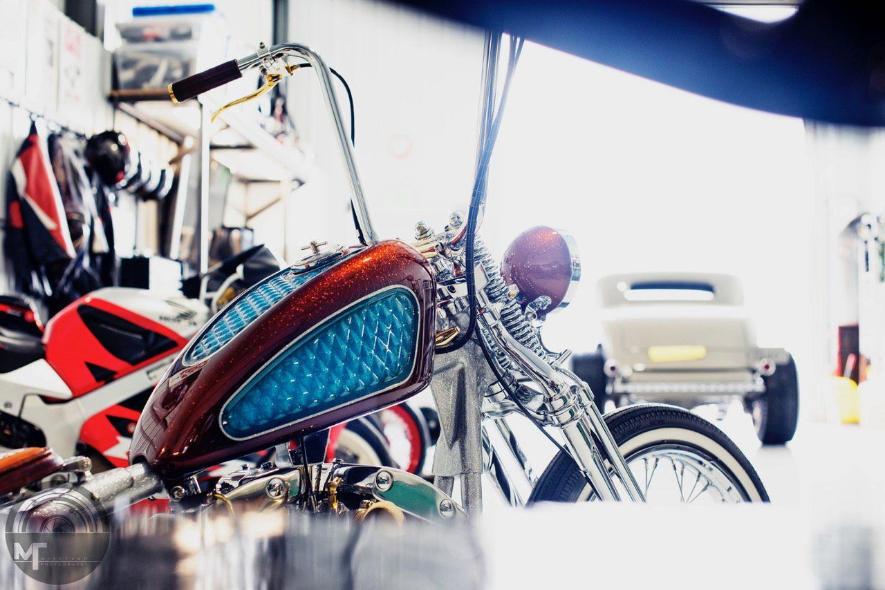 Custom chopper motorcycle with red and blue flames in a bright garage workshop