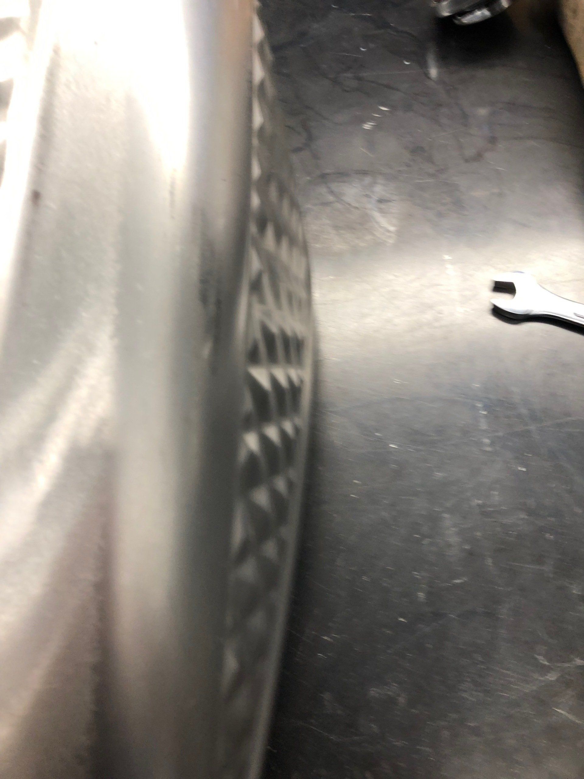 Close-up of a gray textured object beside a black floor with a small white piece on the right