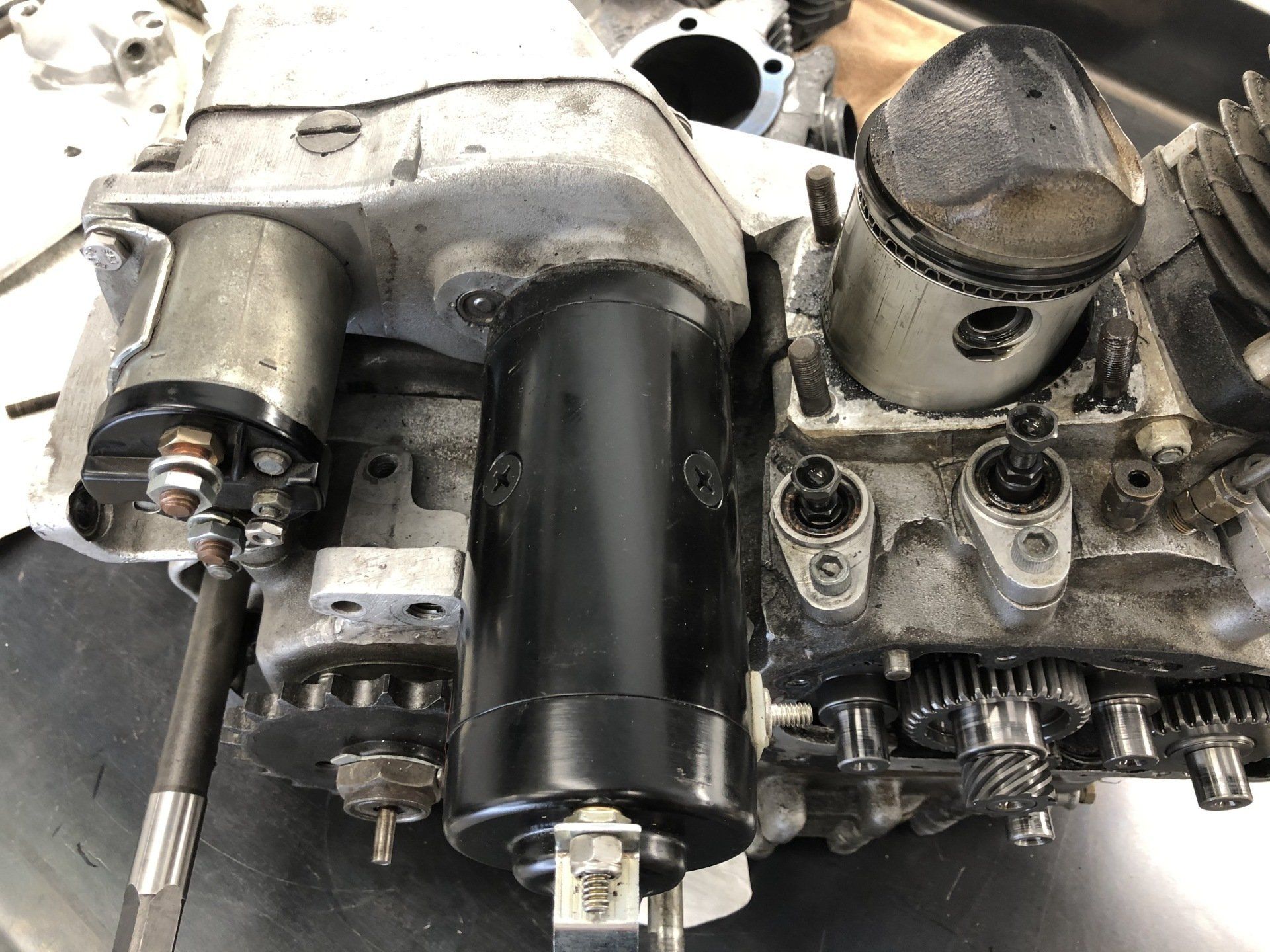 Close-up of an exposed mechanical engine assembly with gears, cylinders, and wiring.