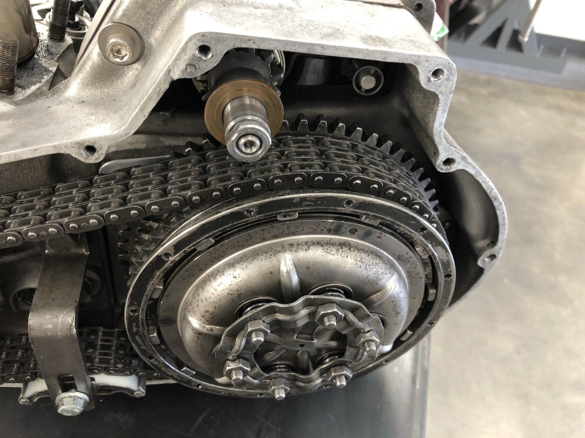 Close-up of a motorcycle engine timing chain and sprocket inside the metal engine case