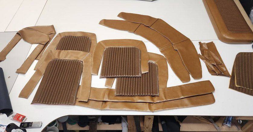 Brown cardboard cutouts and corrugated pieces laid out on a white worktable, like a packaging prototype.