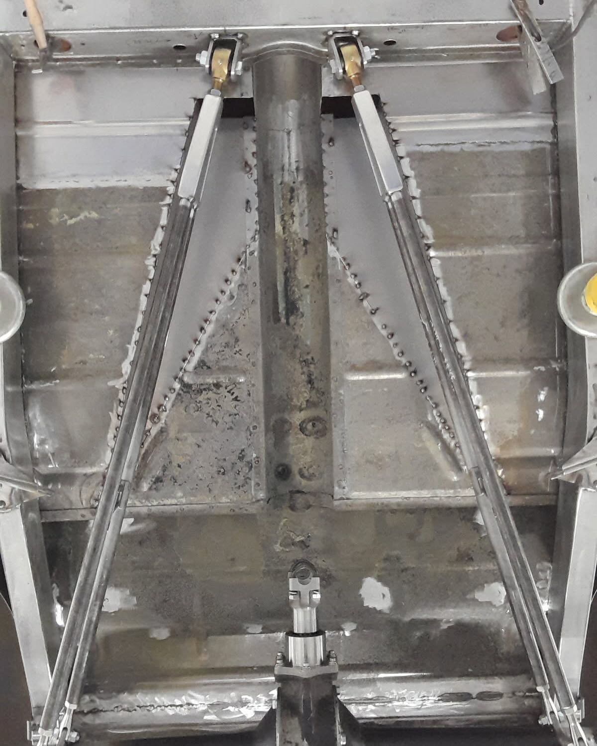 Metal structural frame with diagonal braces inside a gray industrial enclosure