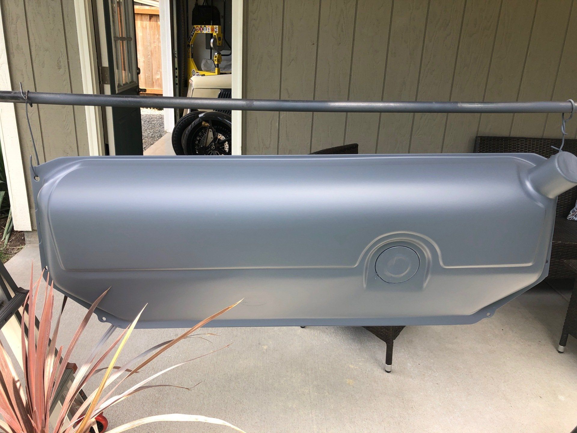 Gray hard-shell rooftop cargo box mounted on a vehicle in a driveway.