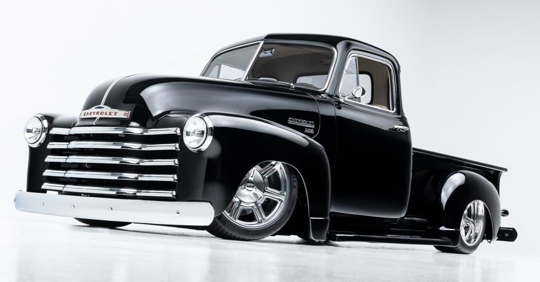 Black vintage pickup truck on a white background, low angle front view.