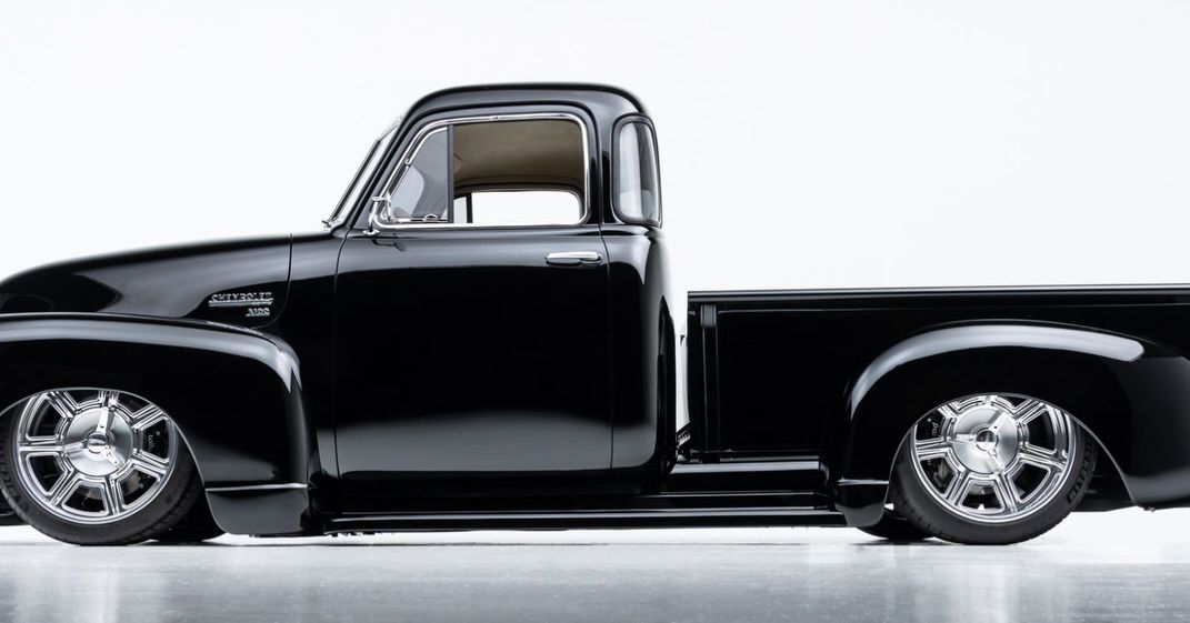 Classic black pickup truck in side view on a white background