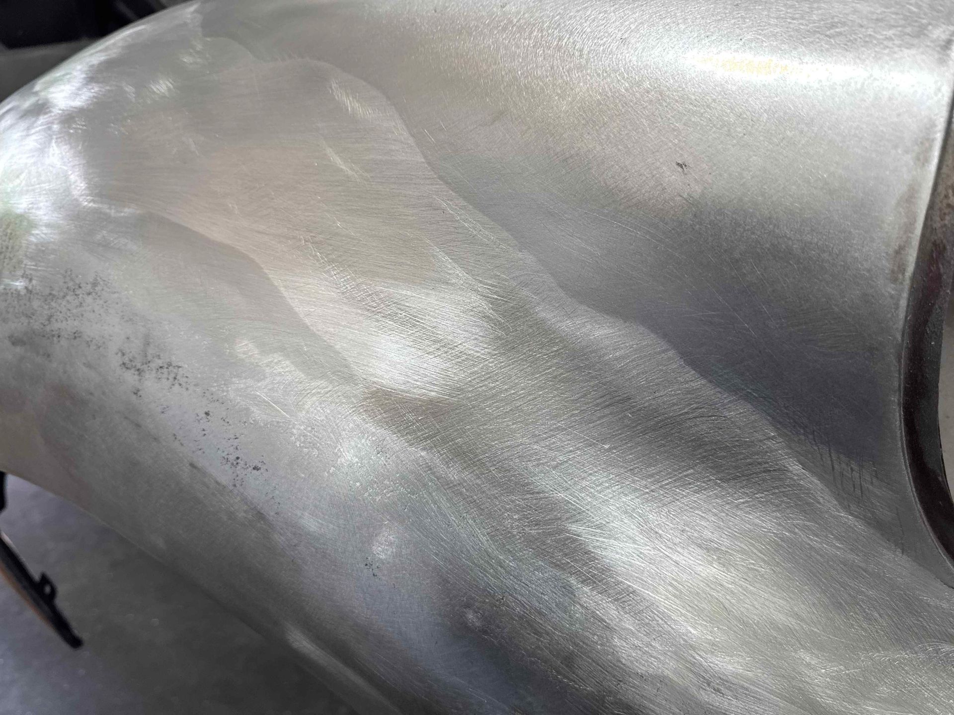 Close-up of a silver metallic car body panel with a black trim edge