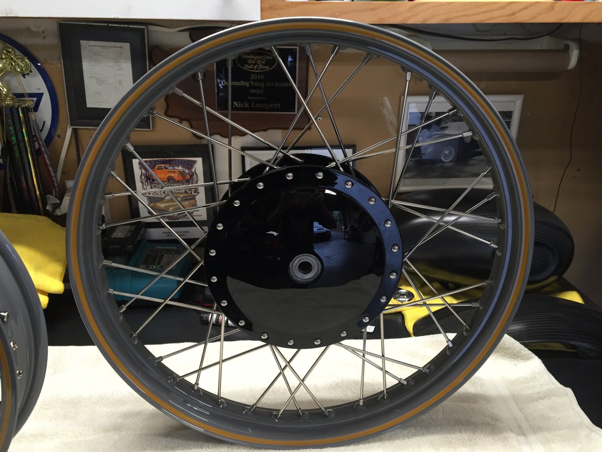 Close-up of a spoked wheel with a black hub motor resting indoors.