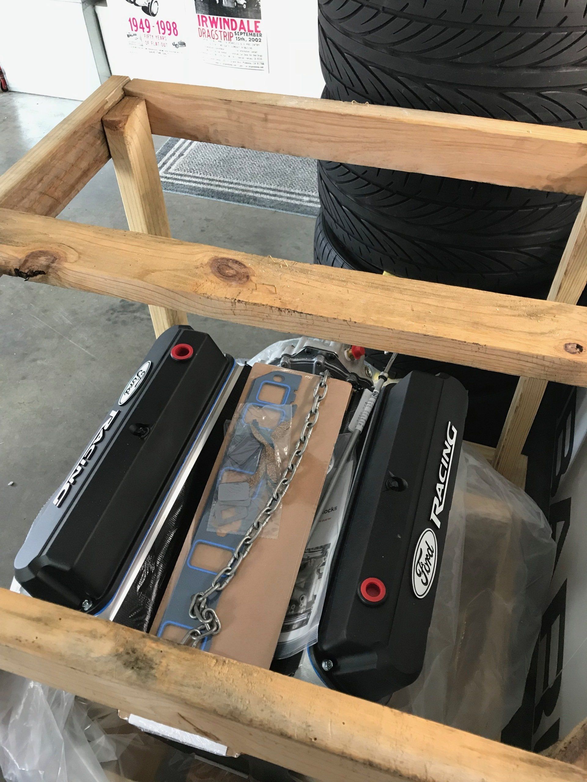 Two black electronics units strapped into a wooden crate on a clear plastic-wrapped item.
