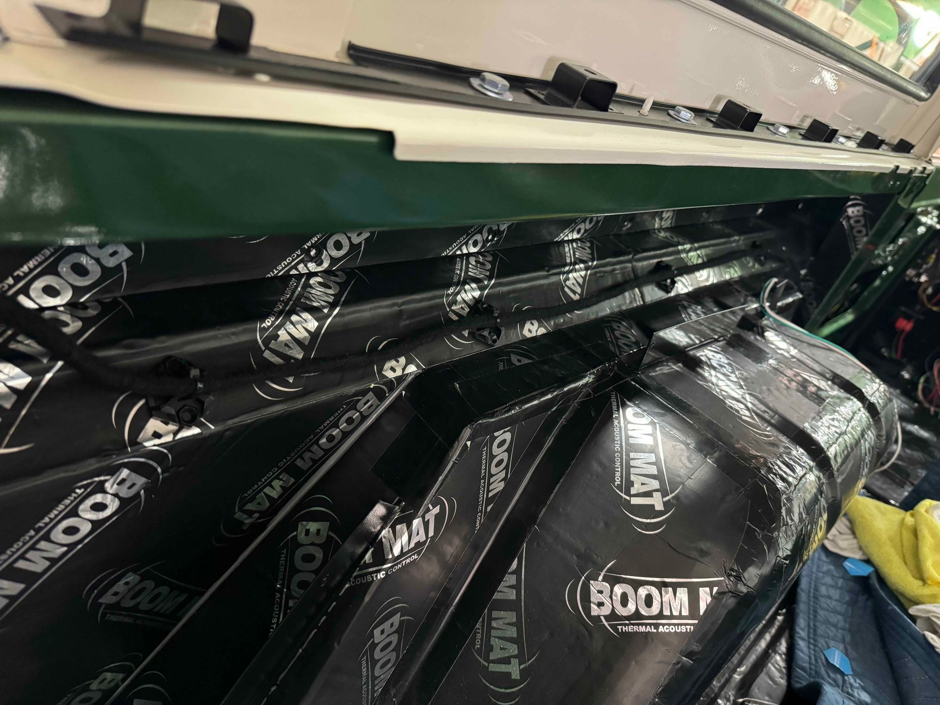 Black soundproofing foam stacked inside a car trunk with the rear hatch open