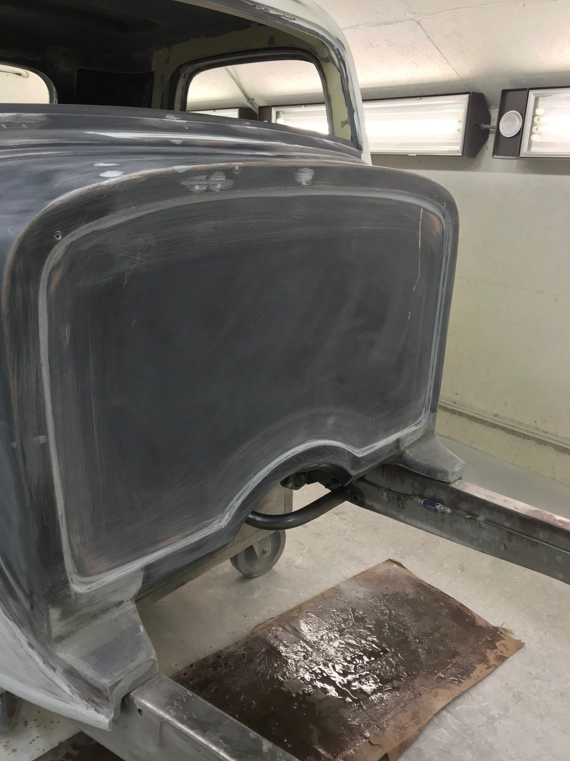 Close-up of a gray vehicle seat back with a worn floor mat beneath it