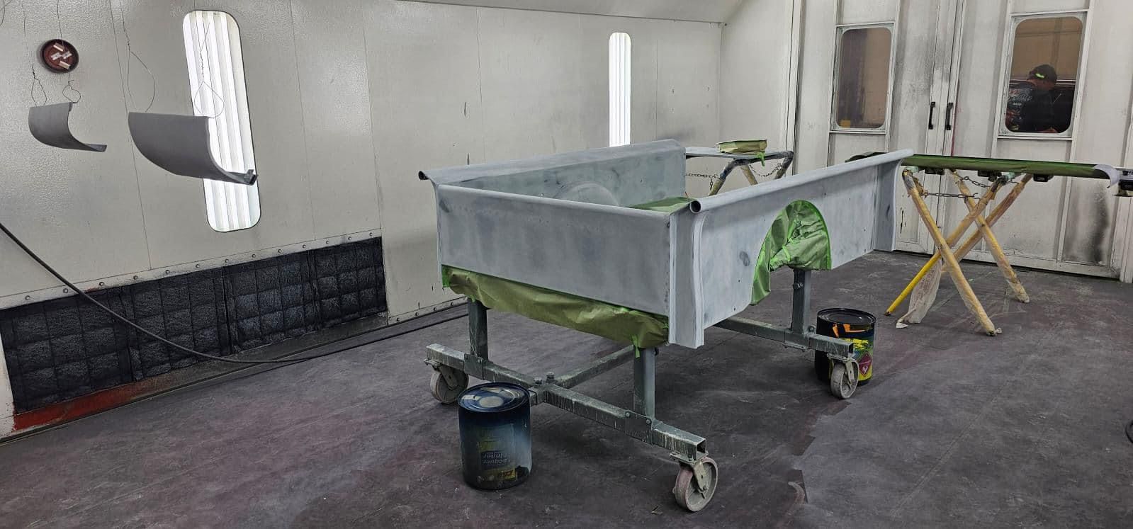 Workshop room with a wheeled metal tray and tools on the floor near the wall.
