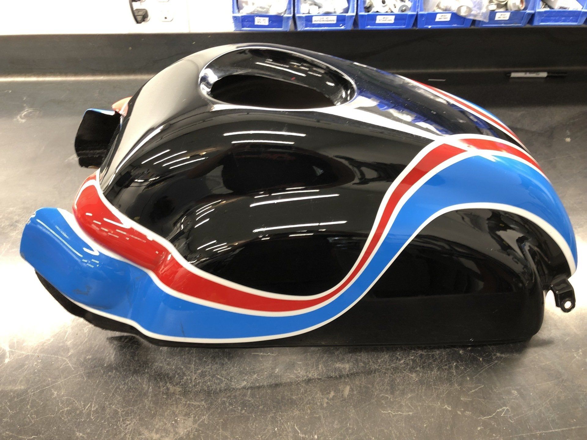 Black, blue, and red bicycle helmet with aerodynamic vents on a display table