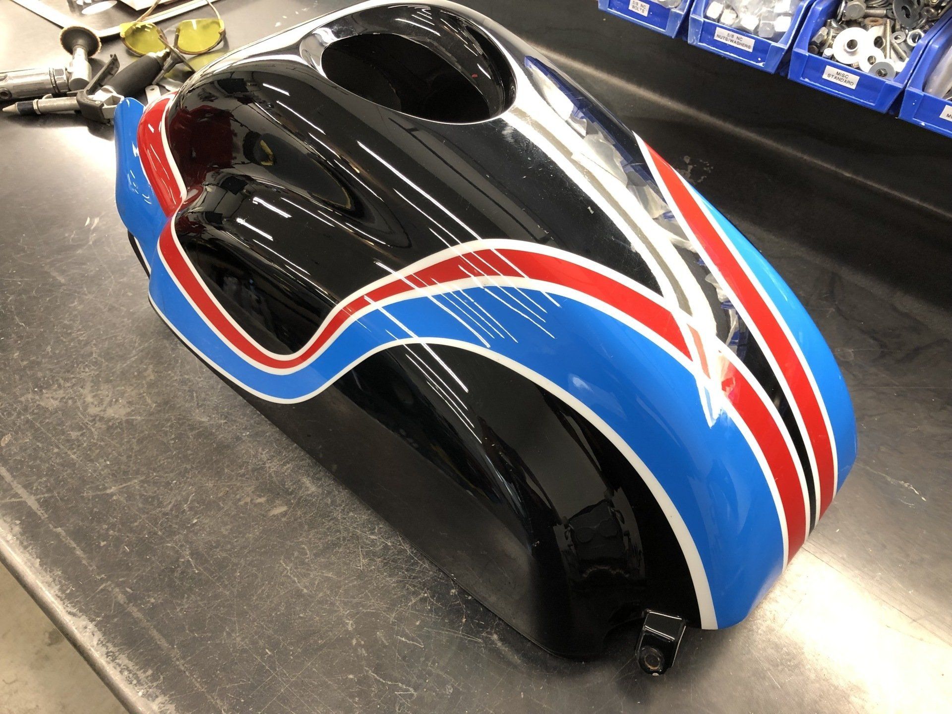 Black stroller with red and blue racing stripes on a showroom floor