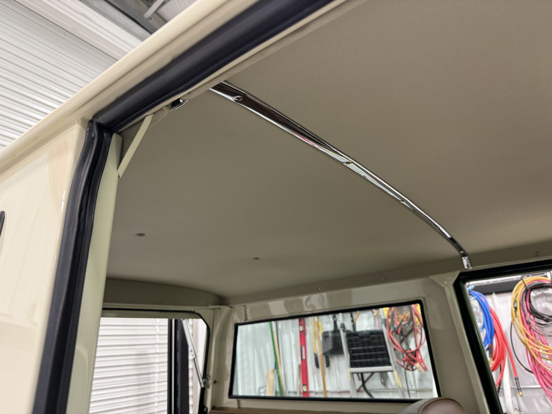 Interior of a white van with open side door and visible ceiling trim and window frame