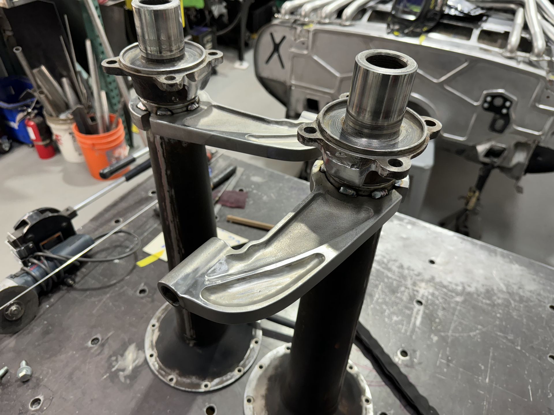 Metal mechanical assembly with two flanges and a curved polished bracket on a workbench