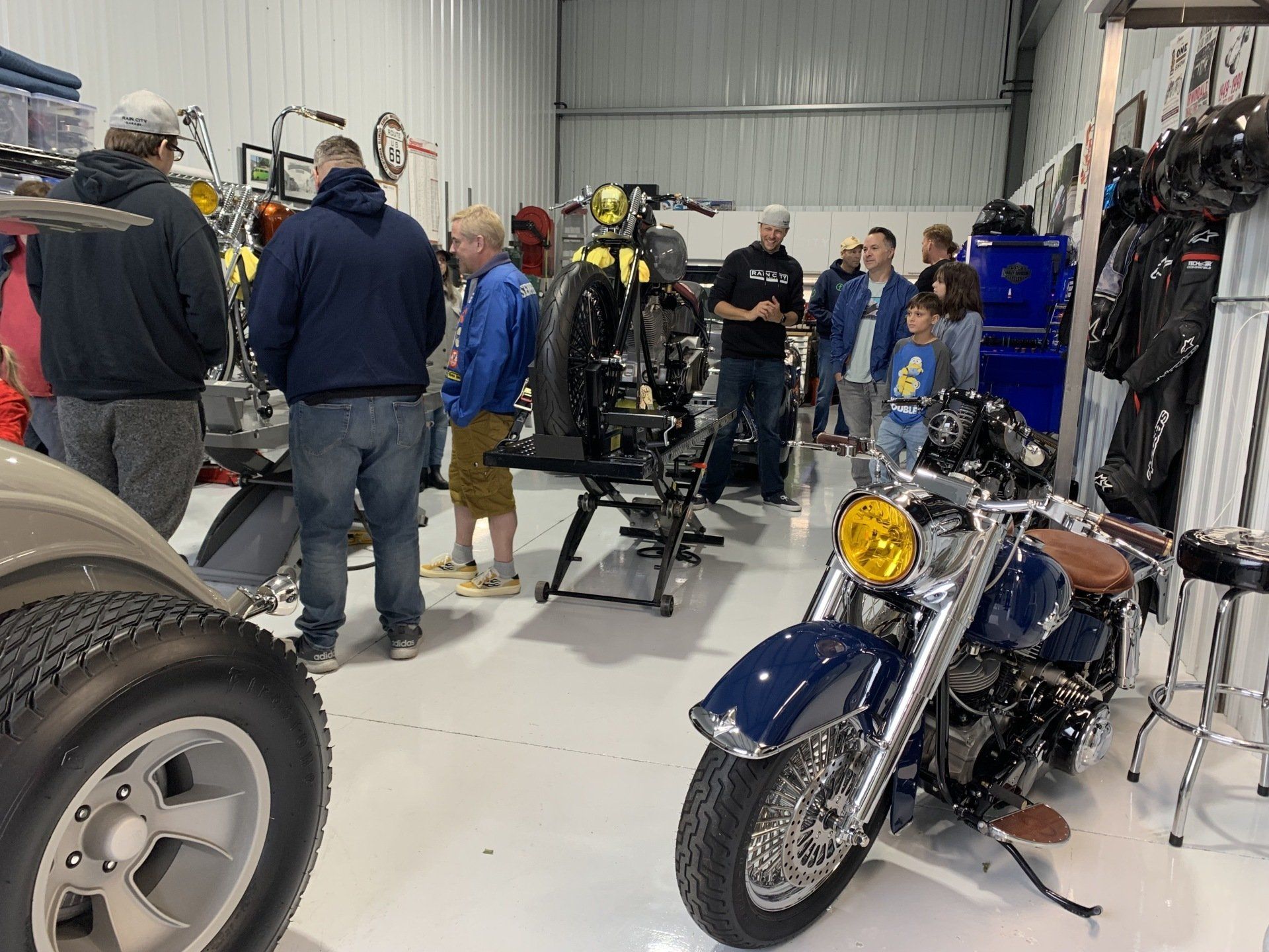 Motorcycle showroom with several bikes and people browsing inside a large garage-like space