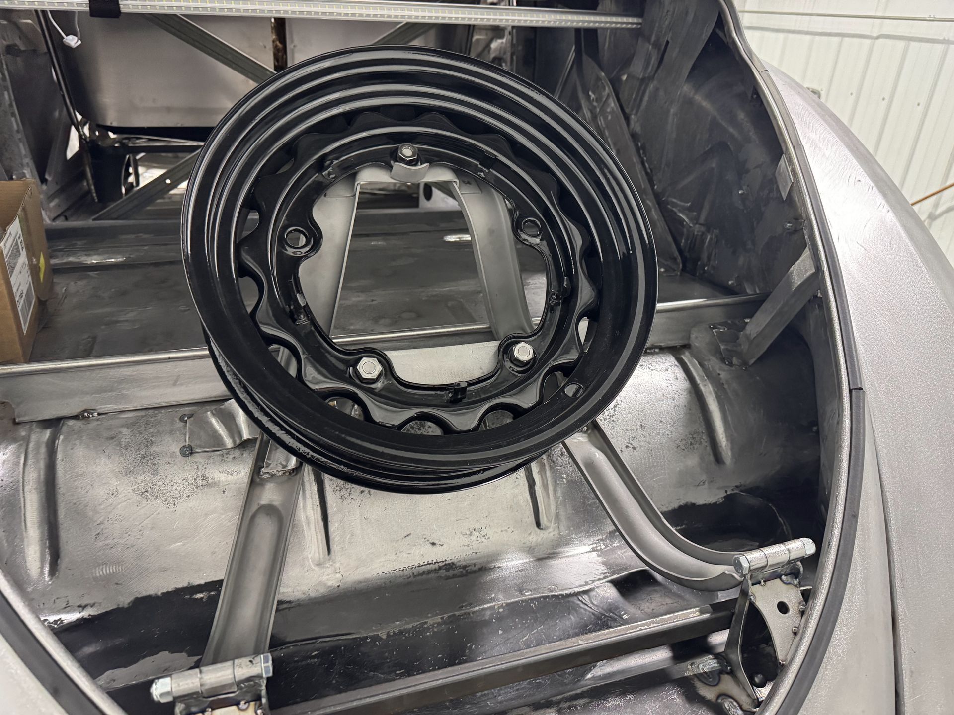 Black coiled hose and metal frame inside a silver industrial machine compartment