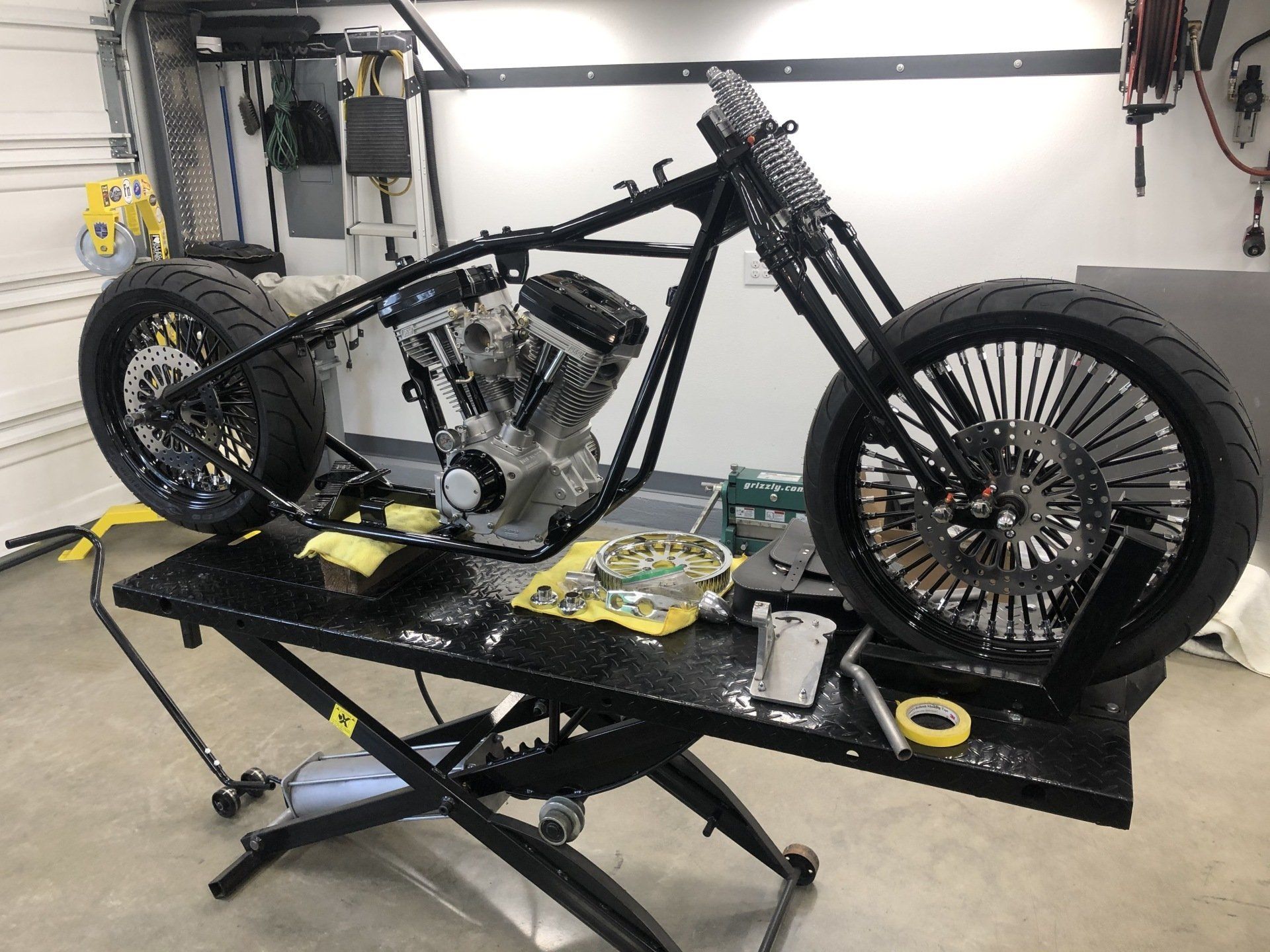 Custom motorcycle frame on a lift in a workshop garage