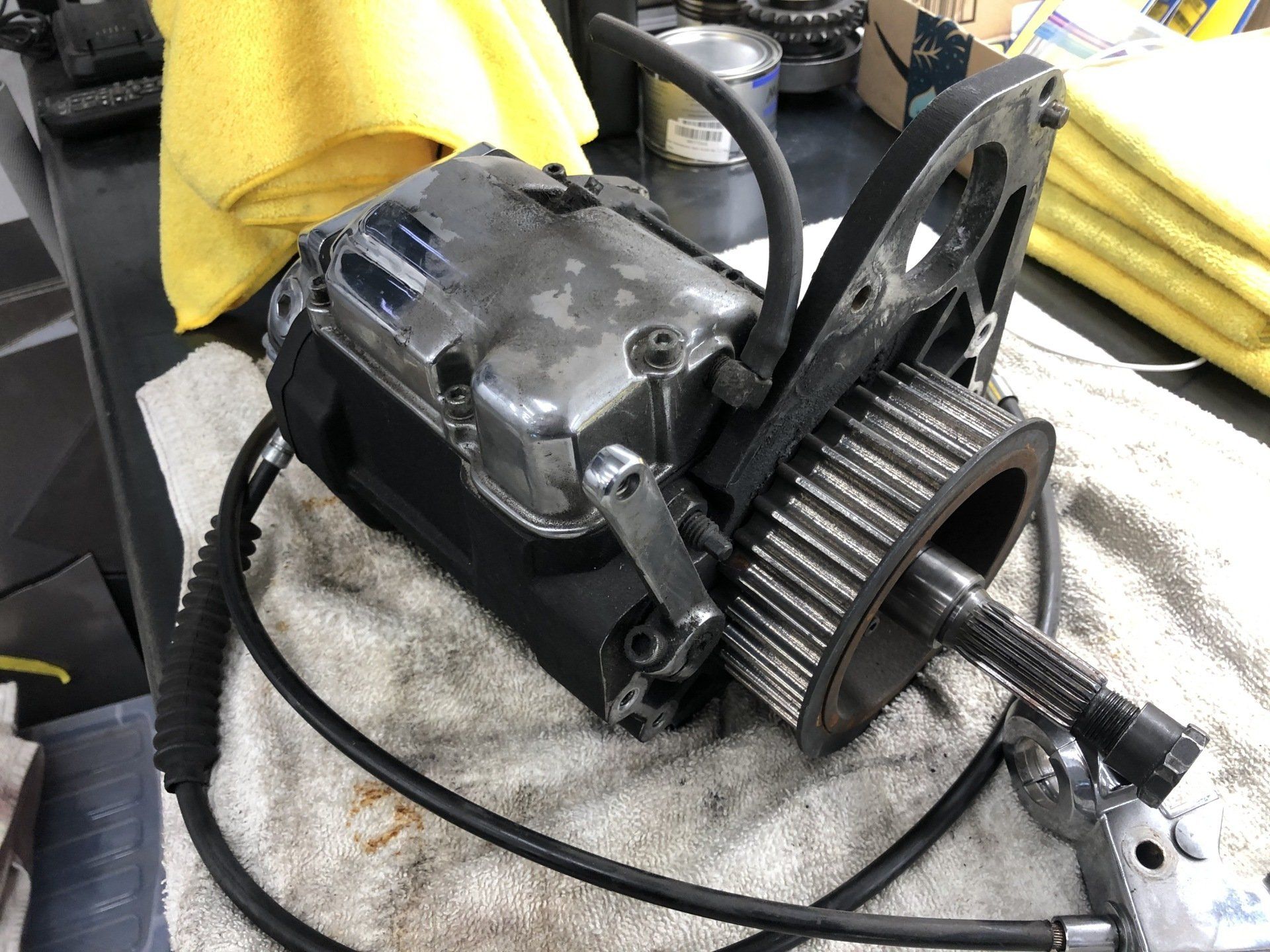 Close-up of a metal mechanical assembly with a pulley and attached cable on a workbench