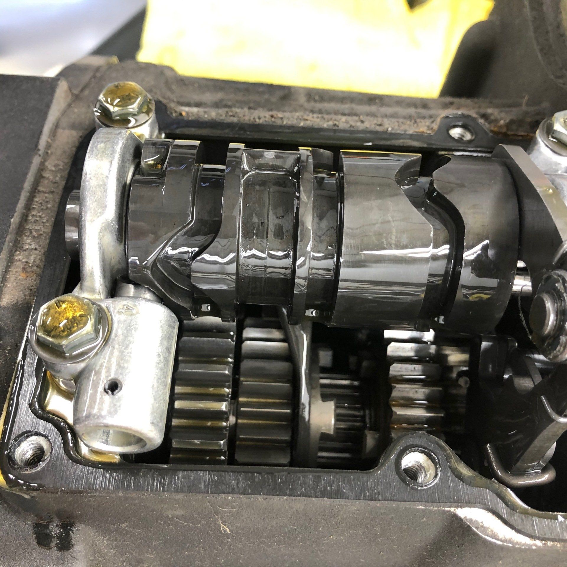Close-up of an exposed metal gear and camshaft assembly inside a small engine casing.