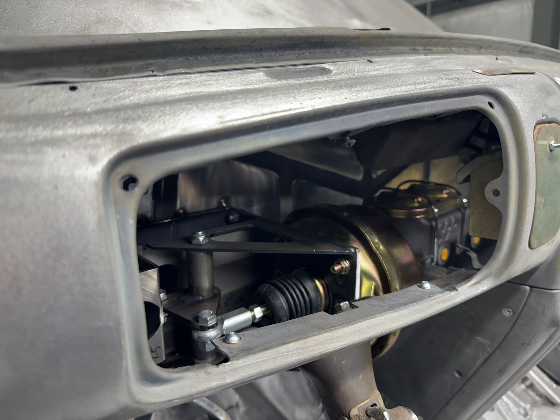 Car dashboard glovebox removed, exposing wiring and mechanical components inside the opening