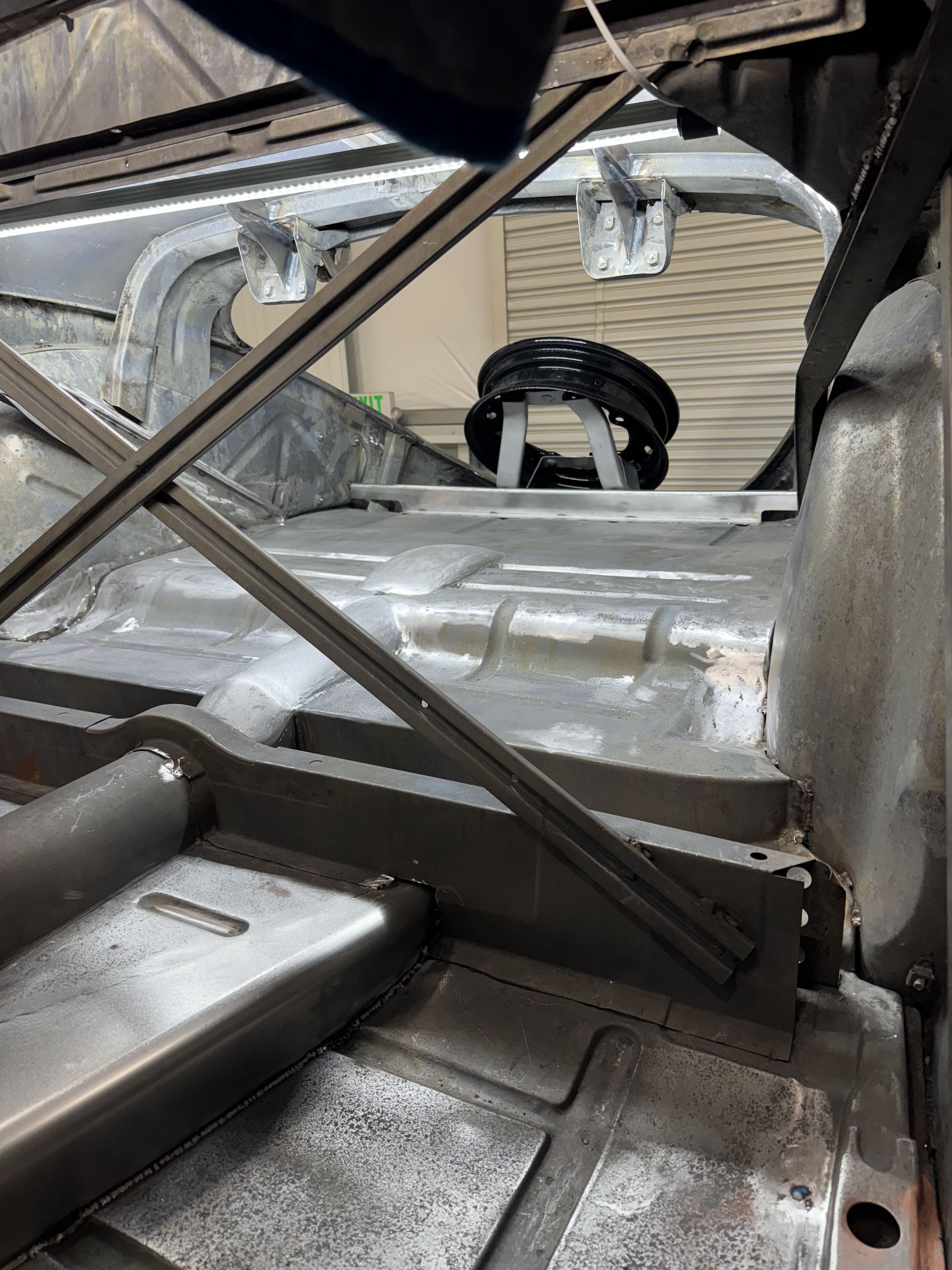 Damaged metallic interior of a vehicle or machine, showing bent panels and structural supports.