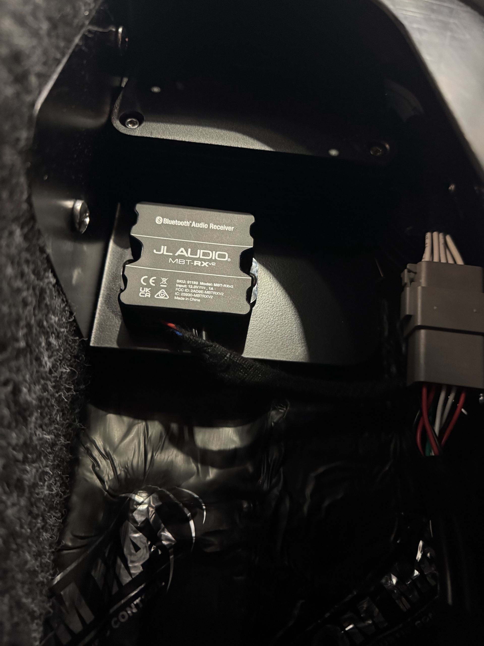 Close-up of a black device interior with a small labeled component and connected wires inside a curved housing
