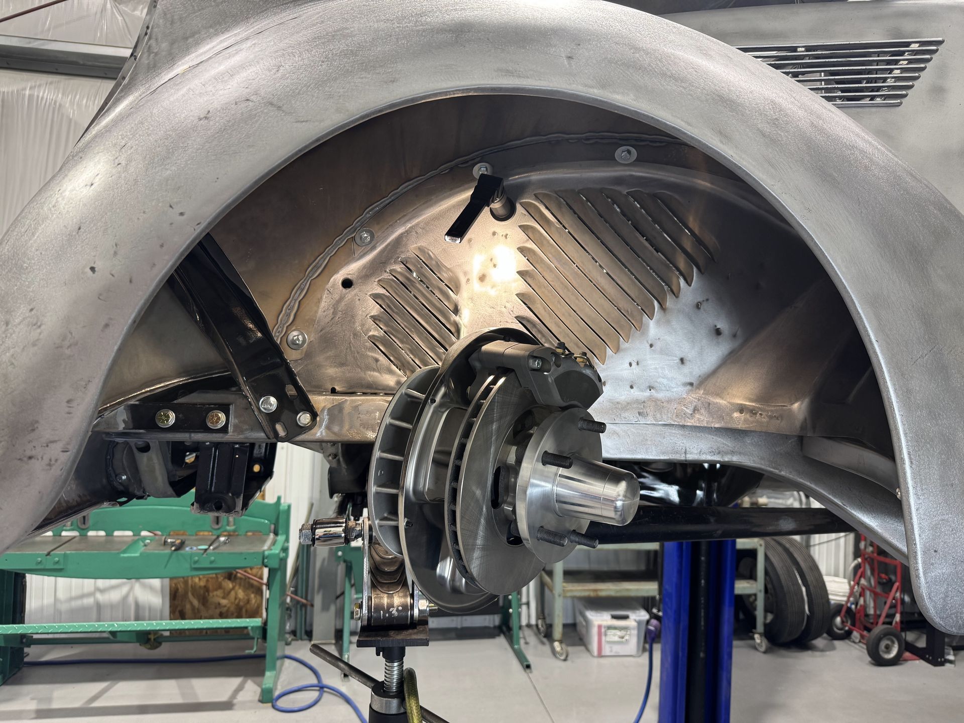 Large metal machinery assembly in a workshop, with a central shaft and circular housing under repair