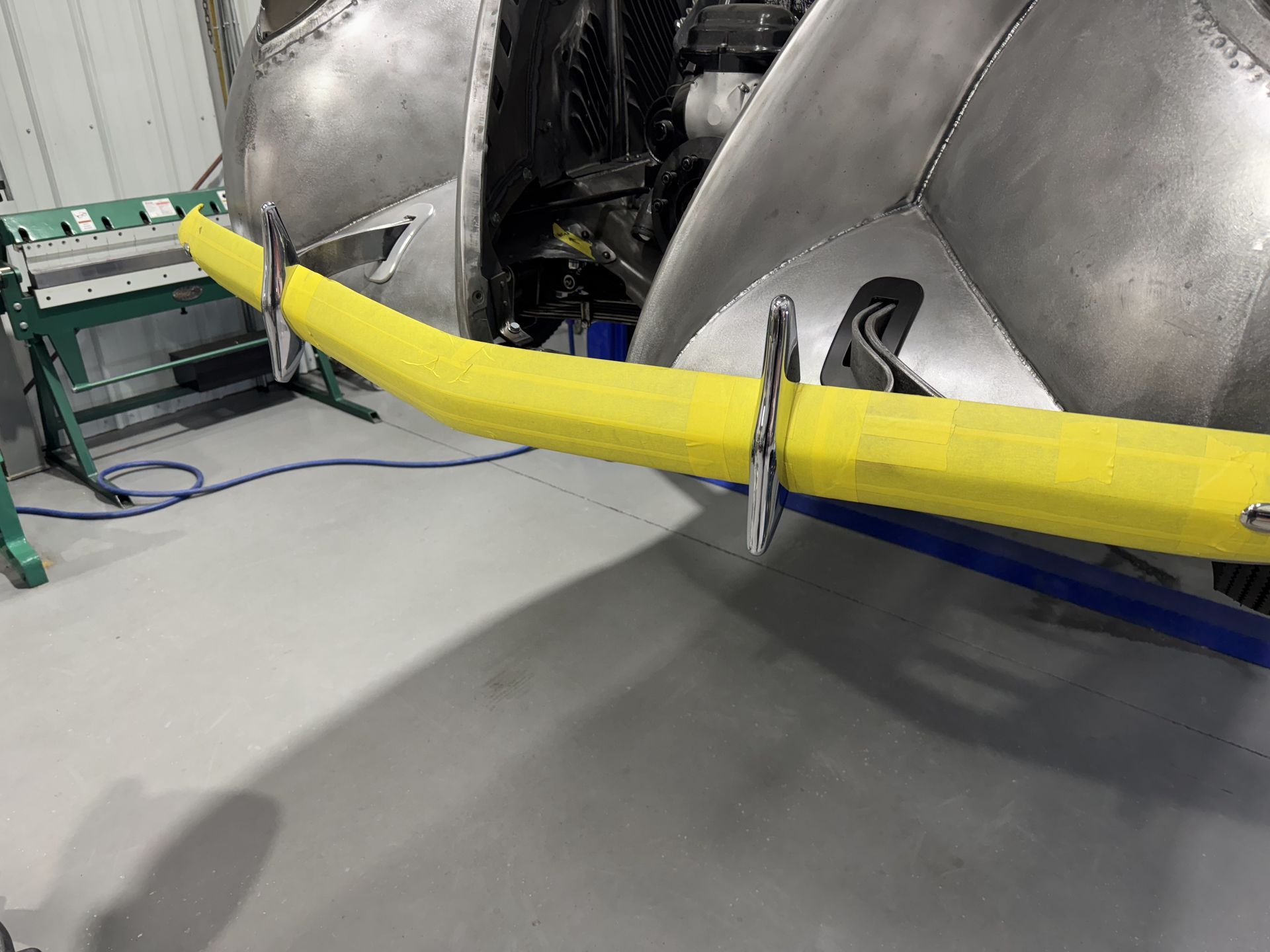 Yellow hose or cable draped across a metal industrial machine in a workshop