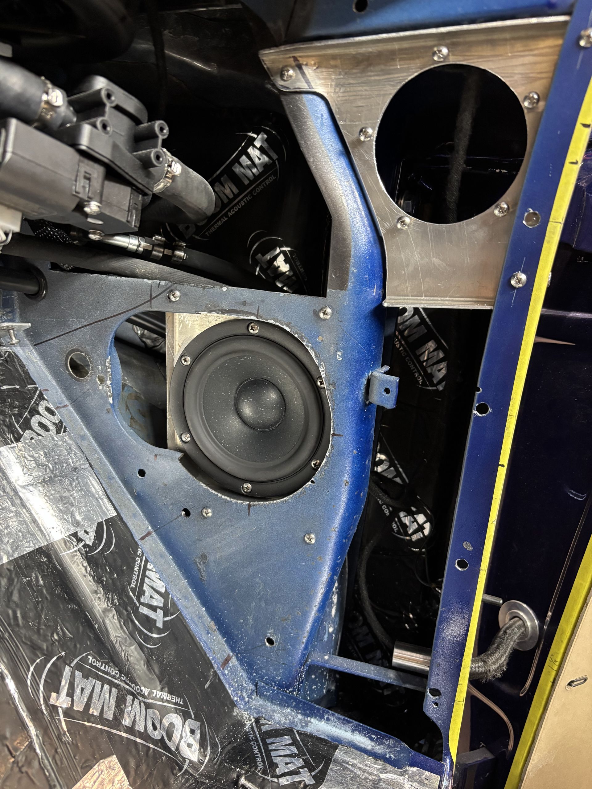 Close-up of a blue and black machine with a visible speaker and circular openings